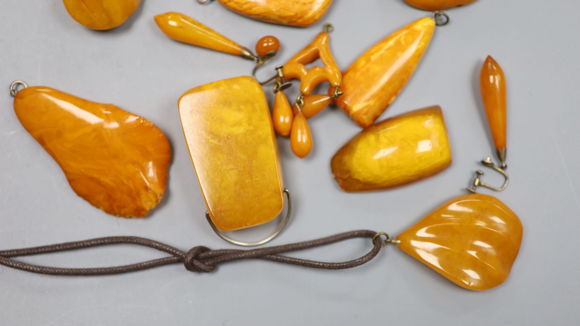 A group of assorted amber jewellery including, earrings, brooches and pendants, gross weight 136 grams.